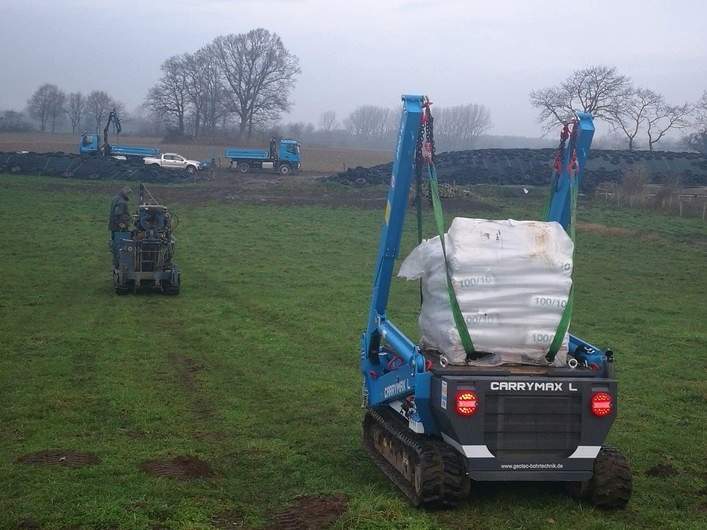 Raupentransporter Carrymax und Bohrgerät auf Raupenfahrwerk auf einem Feld