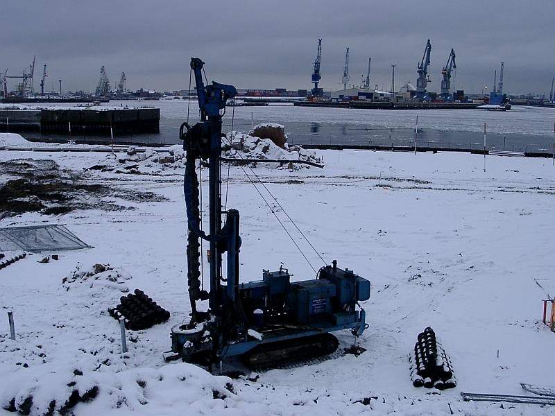Bohrgerät im Schnee in der Hamburger HafenCity, Hafenkräne im Hintergrund
